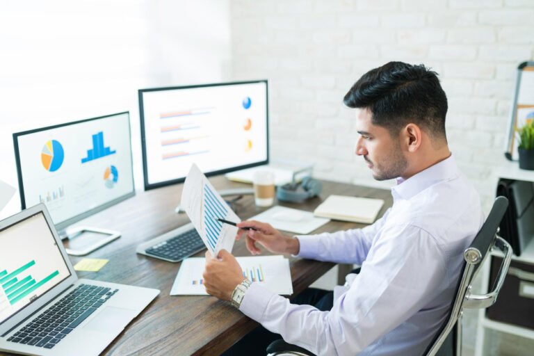 Profissional analisando documentos e dados em uma tela para realizar background check na contratação.
